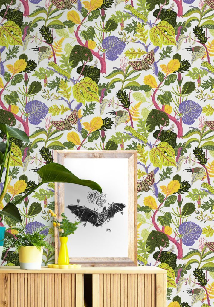 A colorful wallpaper called Caterpillar which displays a lively botanical trail of linear leaves, flowers, caterpillars and butterflies created in collaboration with Llewellyn Mejia