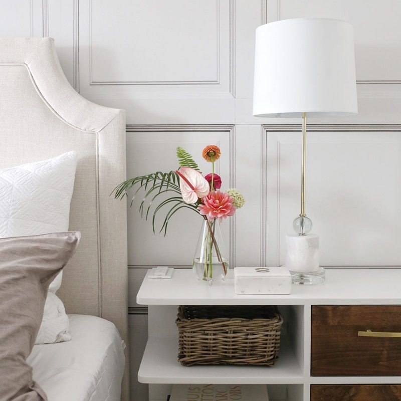 Bedroom space designed by Jillian Harris with The Parlour wallpaper manufactured and sold by Milton & King with a simple beautiful flower arrangement on the end table.