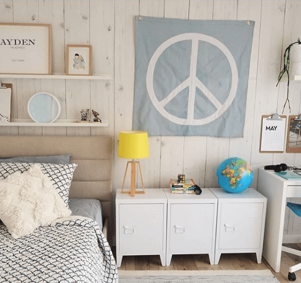 Teenagers bedroom with Whitewashed Timber wallpaper, the best seller for 2017, hung vertically with a peace sign on the wall