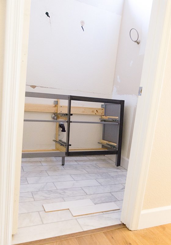 Picture of the bathroom with the remodeling in progress. A frame of the cabinet vanity