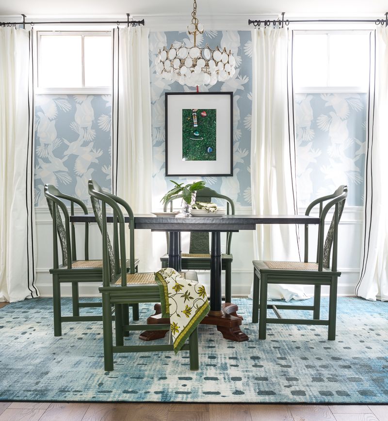 Jewel Marlowe Basement Makeover • A blue carpet with a kitchen table with green chairs and light blue magpie wallpaper from Milton & King on the wall